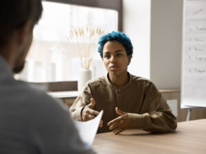 Young blue-haired African woman passes job interview