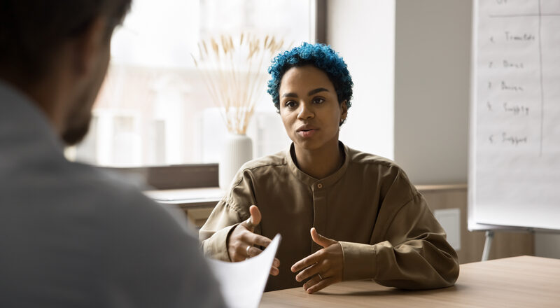 Young blue-haired African woman passes job interview